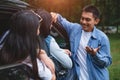 Asian man talking to women in car during travel in forest. Boy flirting girls for meeting. People lifestyles and weekend tour Royalty Free Stock Photo