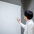 Asian man teacher writing on blank whiteboard Royalty Free Stock Photo