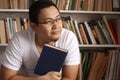 Asian man thinking while reading book, education concept, learning studying in library Royalty Free Stock Photo