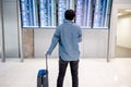 Asian man tourist at arrival departure board in airport Royalty Free Stock Photo