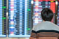 Asian man tourist looking at arrival departure board Royalty Free Stock Photo