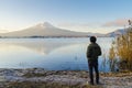 Asian man traveler looking sunrise and mount fuji reflect on water Royalty Free Stock Photo