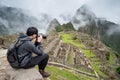 Asian man traveler taking photo at Machu Picchu