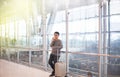 Asian man traveler using mobile phone in airport,Lifestyle using cell phone connection concept,Feeling happy and smiling Royalty Free Stock Photo