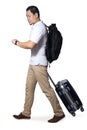 Asian man traveler walking forward drag his suitcase luggage while looking at his watch, wearing casual shirt and backpack, full Royalty Free Stock Photo
