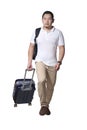 Asian man traveler walking forward drag his suitcase luggage, wearing casual shirt and backpack, full length portrait isolated on Royalty Free Stock Photo