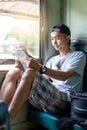 Asian man traveling backpacker reading map sit on the old train Royalty Free Stock Photo