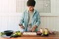 Asian man trying to cook with a recipe, Salad canned fish from the mobile phone. people online learning cooking experience on