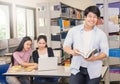 Asian man with two asian college students using laptop in the library Royalty Free Stock Photo