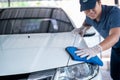 Asian man in uniform holds the microfiber in hand and polishes the car, Car wash service concept Royalty Free Stock Photo