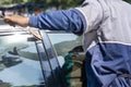 Asian man uses long metal to break door into a vehicle, Man forgot the key inside of his car Royalty Free Stock Photo