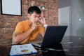 Asian man uses a notebook computer and works hard and meeting at home and he is stressed and Headache Royalty Free Stock Photo