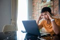 Asian man uses a notebook computer and works hard and meeting at home and he is stressed and Headache Royalty Free Stock Photo