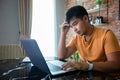 Asian man uses a notebook computer and works hard and meeting at home and he is stressed and Headache Royalty Free Stock Photo