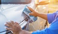 Asian man using blue sponge with soap to washing the car at outdoor in sunset time Royalty Free Stock Photo