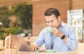Asian man using laptop in coffee shop, Man speak talk on video call with colleagues on online meeting, Technology in use concepts Royalty Free Stock Photo
