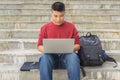 Asian man using laptop, sitting on stair Royalty Free Stock Photo