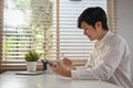 an Asian man using mobile banking application to transfer money or pay online bills Royalty Free Stock Photo