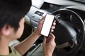 Asian man using mobile phone while sitting in his car. Royalty Free Stock Photo