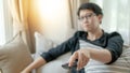 Asian man using remote controller while watching TV Royalty Free Stock Photo