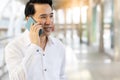 Asian man using smart phone for talking his business  with customer in city Handsome guy get satisfied with full bars or good Royalty Free Stock Photo