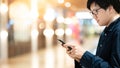 Asian man using smartphone in shopping mall Royalty Free Stock Photo