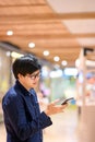 Asian man using smartphone in shopping mall Royalty Free Stock Photo