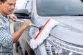 Man using white mop with soap to washing the car at outdoor. Car cleaning and maintenance concept Royalty Free Stock Photo