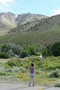 Asian man visiting and taking photo of the Sierra Nevada range mountai