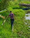 Asian man walking on dangerous bamboo bridge