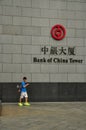 Asian man walking in front of the Bank of China tower. Hong Kong Royalty Free Stock Photo