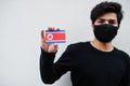 Asian man wear all black with face mask hold North Korea flag in hand isolated on white background. Coronavirus country concept