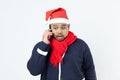 Asian man weared blue sweater, santa hat, red scarf using mobile phoe calling