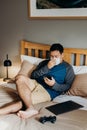 Asian man weared medical mask. Sitting and using cell phone in bedroom