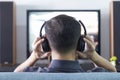 Asian man wearing black headphones enjoying home entertainment