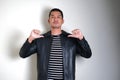 Asian man wearing black leather jacket pointing his self with arrogant expression Royalty Free Stock Photo