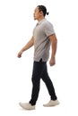 Asian man wearing casual grey shirt black denim and white shoes, walking forward, side view, happy confidence expression. Full Royalty Free Stock Photo