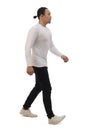 Asian man wearing casual white shirt black denim and white shoes, walking forward, side view, happy confidence expression. Full Royalty Free Stock Photo