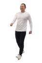 Asian man wearing casual white shirt black denim and white shoes, walking forward, side view, happy confidence expression. Full Royalty Free Stock Photo