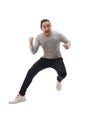 Asian man wearing grey shirt black denim and white shoes, jump while screaming shouting celebrating victory, winning gesture Royalty Free Stock Photo