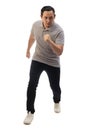 Asian man wearing grey shirt black denim and white shoes, looking at camera seriously, ready to run, front view. Full body Royalty Free Stock Photo