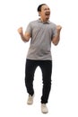 Asian man wearing grey shirt black denim and white shoes, screaming shouting celebrating victory, winning gesture. Full body Royalty Free Stock Photo