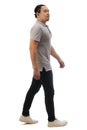 Asian man wearing grey shirt black denim and white shoes, walking forward, side view, happy confidence expression. Full body Royalty Free Stock Photo