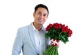 Asian man wearing grey suit holding a bouquet of red roses and red gift box Royalty Free Stock Photo