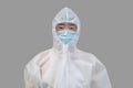 An Asian man wearing protective suit, medical masks, and goggles on a gray background