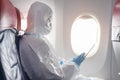 Asian man is wearing protective suit , PPE suit in airplane , safety travel concept