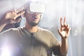 Asian man wearing VR goggles while playing video games with hands reaching out to touch something in virtual world Royalty Free Stock Photo