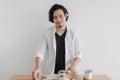 Man in white shirt reading magazine and drink coffee on wooden table. Royalty Free Stock Photo