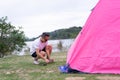 An Asian man in white t shirt setting pink tent