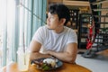 Asian man in white t-shirt waiting for someone to meet at the restaurant. Royalty Free Stock Photo